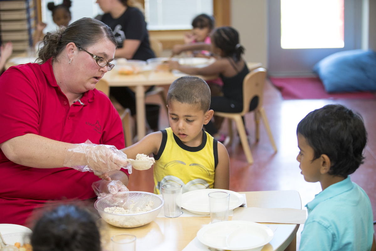 teacher helping student serve self